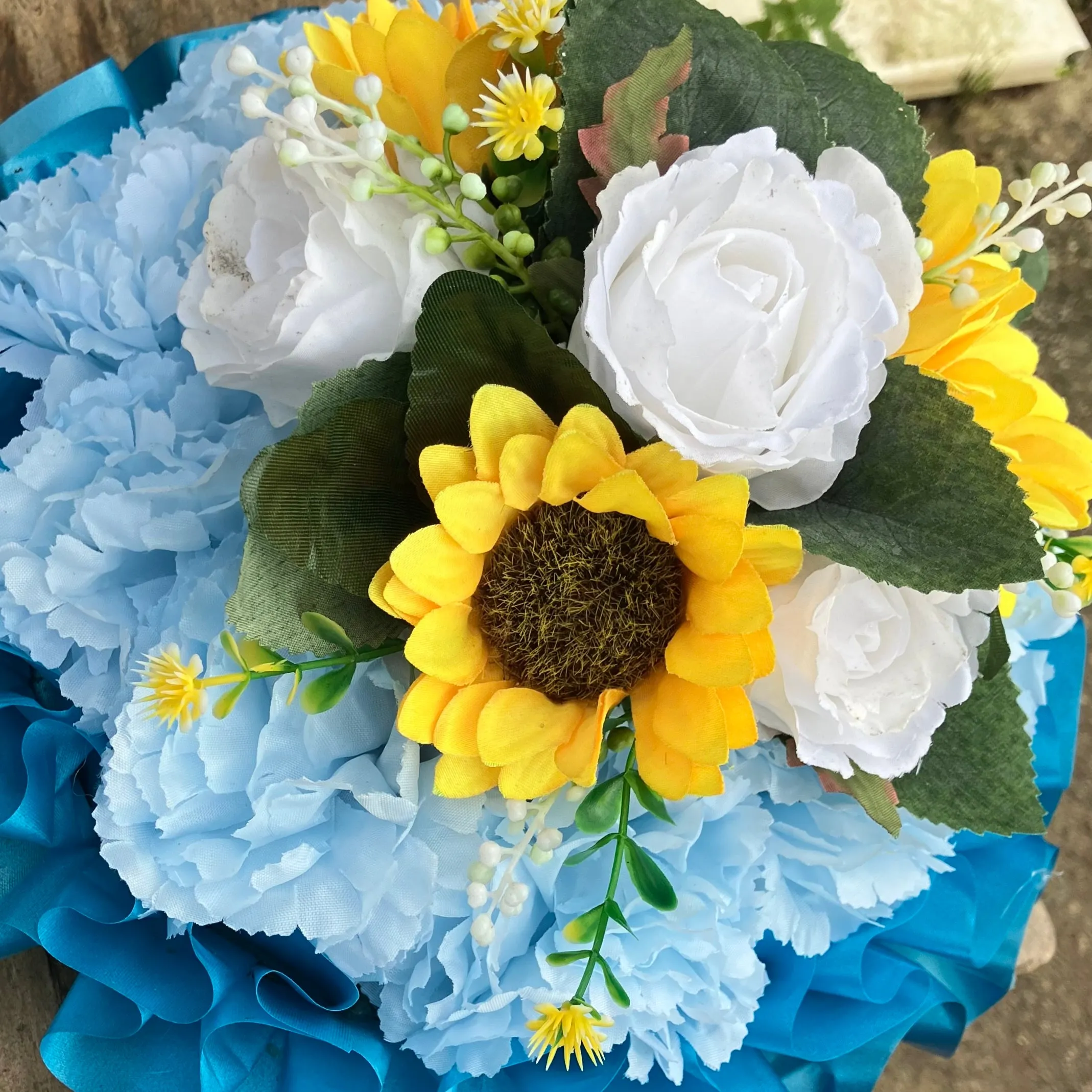 A based posy of silk roses and lily flowers in shades of blue and white