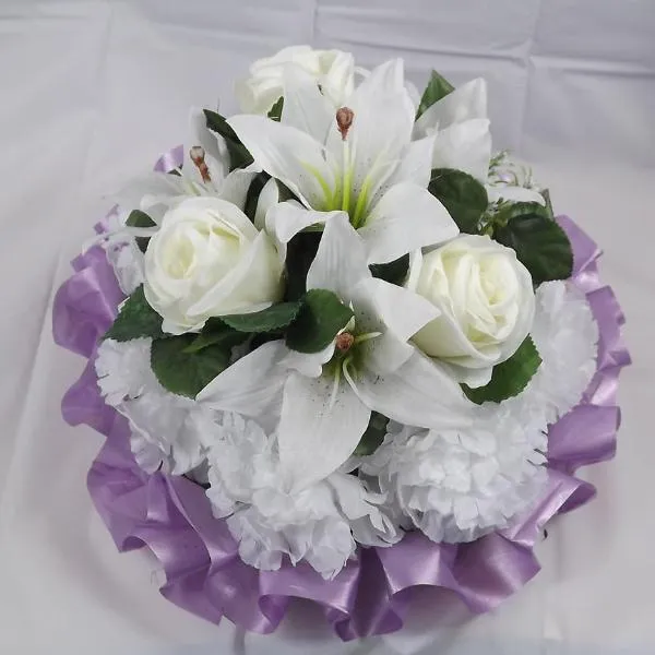 a funeral posy of artificial silk roses and lily flowers in shades of lilac and white